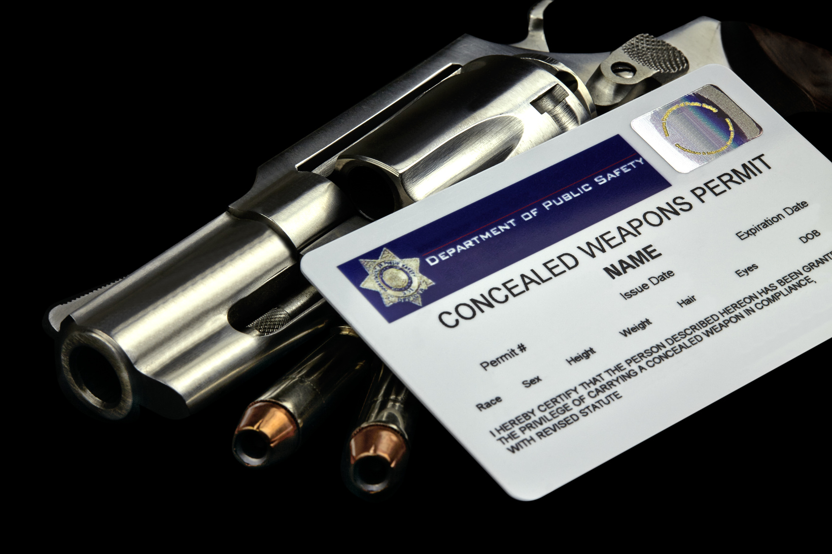 Stainless Revolver and Bullets on top of Arizona Concealed Weapon Permit